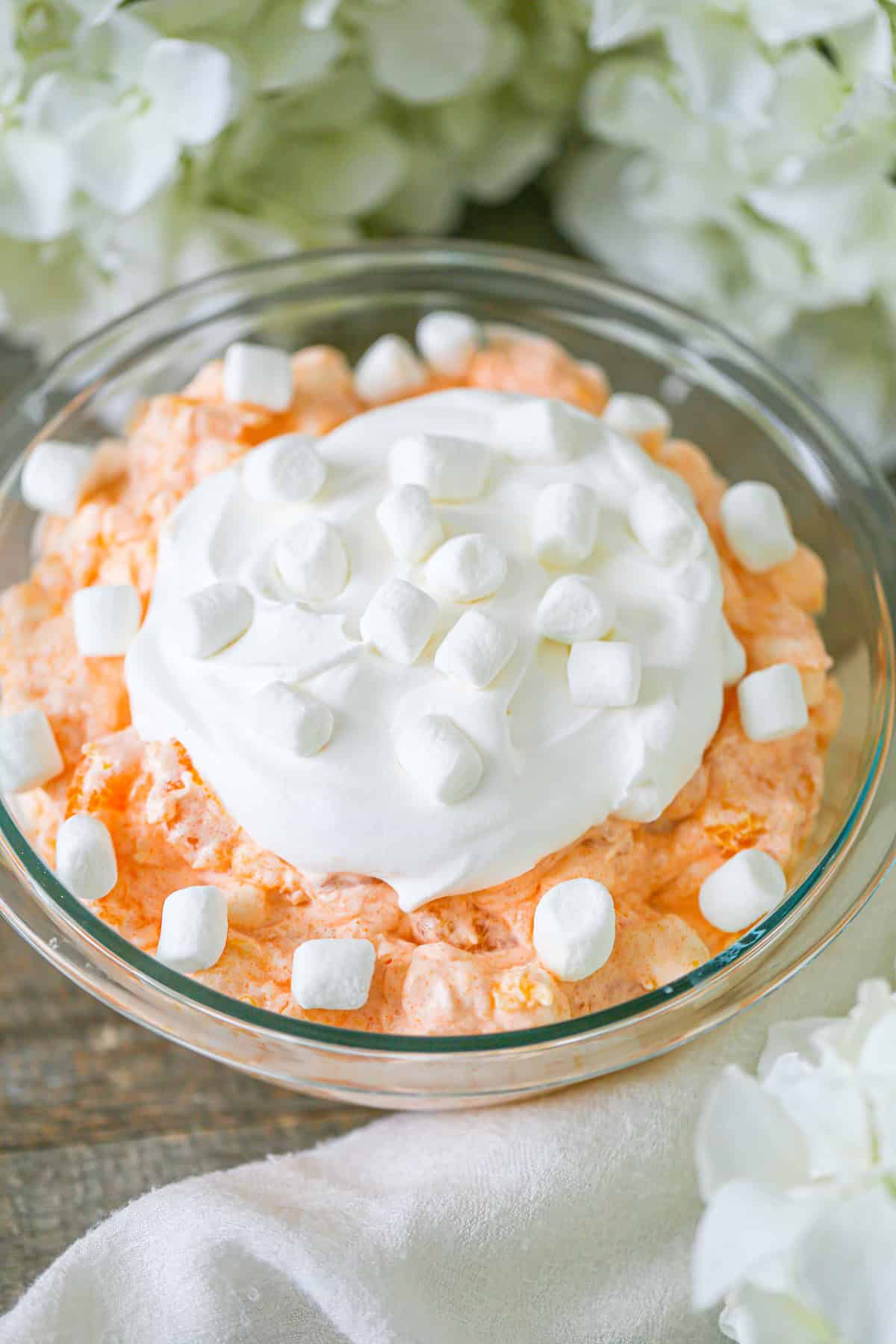 This easy Orange Fluff Salad recipe combines mandarin oranges, marshmallows, cottage cheese & jello. Quick to make & delightfully fluffy!