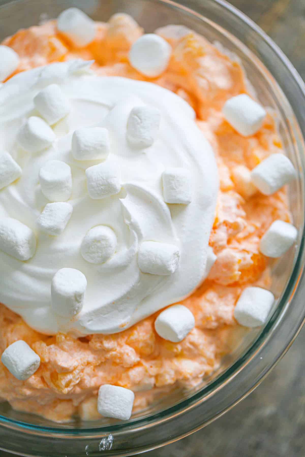 This easy Orange Fluff Salad recipe combines mandarin oranges, marshmallows, cottage cheese & jello. Quick to make & delightfully fluffy!